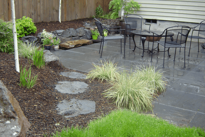 Decorative steel structures, container water feature, and hardscape make up this beautiful side yard.