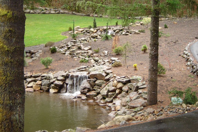 Cascading water splashes across a rock retaining wall.
